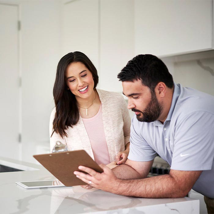 Couple reviewing a document together in a modern kitchen.