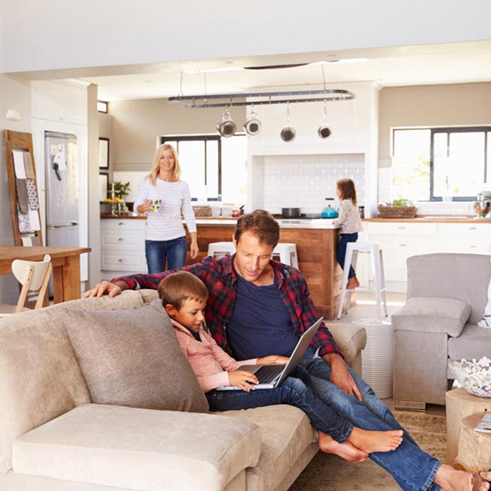 Family enjoying time together in a cozy, modern living room and kitchen.