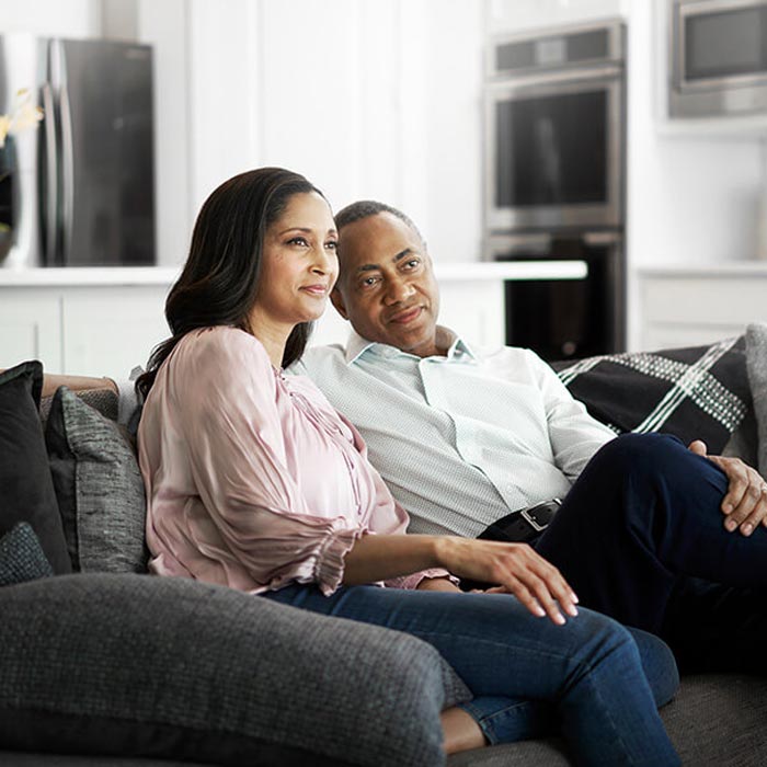 Couple sitting together on a couch in a modern living room.