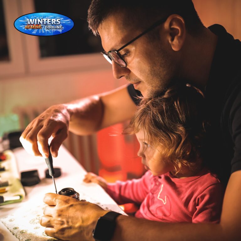 man repairing something with child